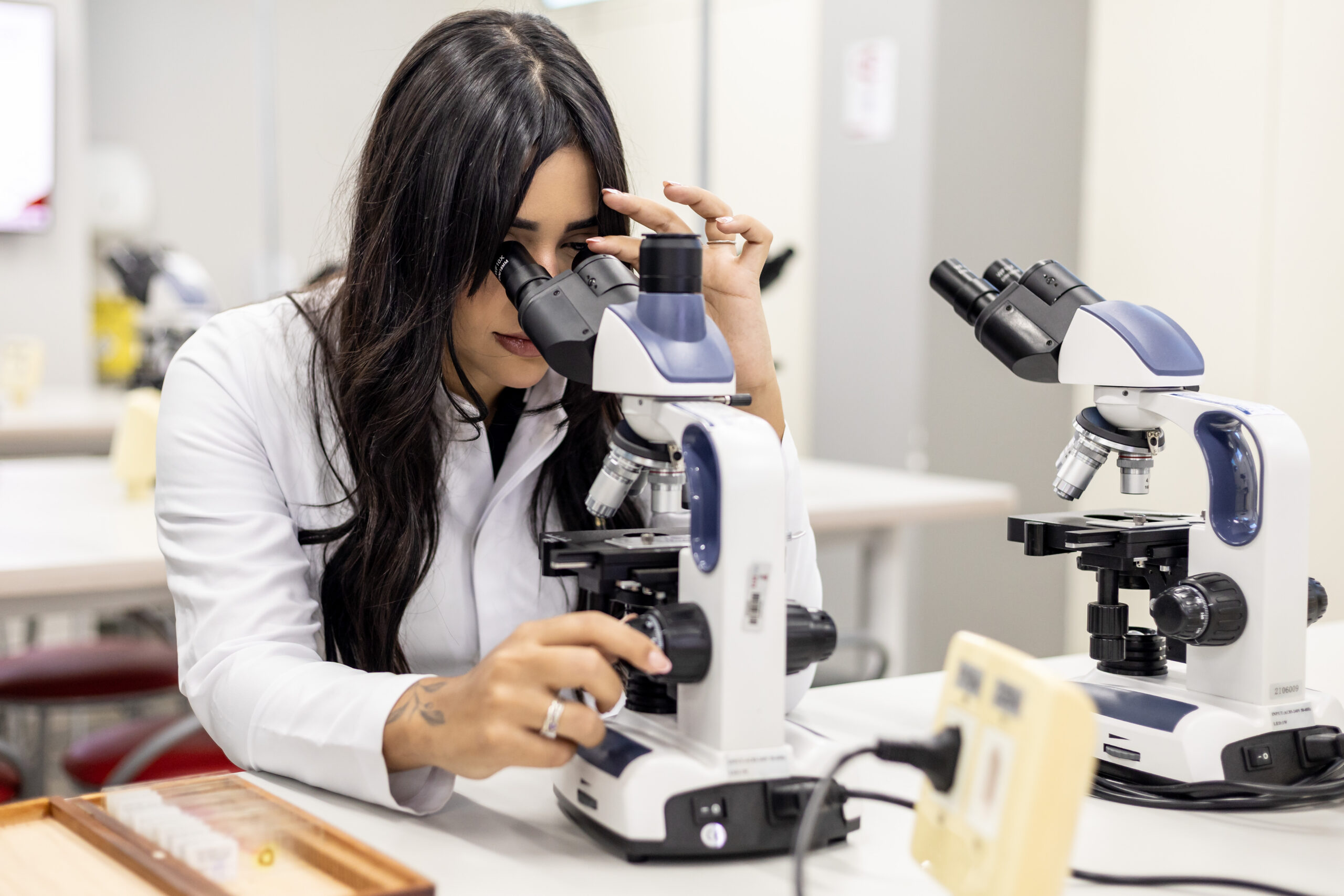 Aluna analisando amostra no microscópio